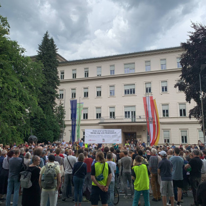 Množica na protestu poleg napisa "Roke stran od Peršmana!"