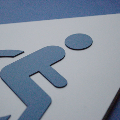 Slika znaka, na katerem je narisan invalidski voziček. Torej označuje pot dostopno za gibalno ovirane osebe.