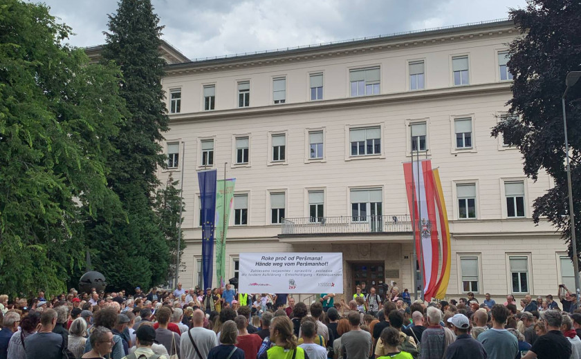 Množica na protestu poleg napisa "Roke stran od Peršmana!"